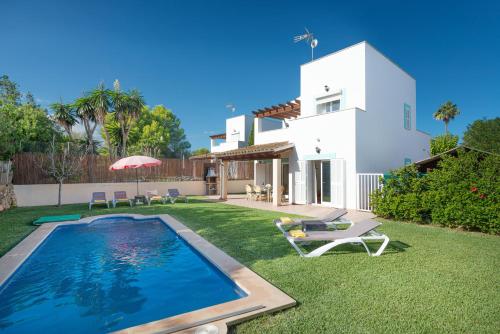 a backyard with a swimming pool and a house at Impresionante Villa Son Ganxo II en Cala Murada! in Cala Murada