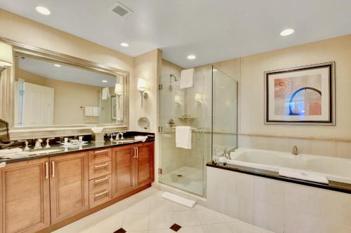 a bathroom with a tub and a sink and a shower at Strip View Suites - No Resort Fee ! in Las Vegas