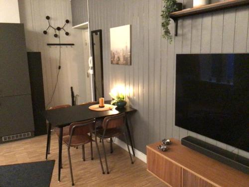 ein Wohnzimmer mit einem Tisch mit Stühlen und einem TV in der Unterkunft Central Grünerløkka, close to city center in Oslo