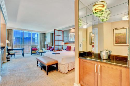 a hotel room with a bed and a living room at Strip View Suites - No Resort Fee ! in Las Vegas