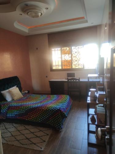 een slaapkamer met een bed en een tafel en ramen bij Villa chadine in Safi