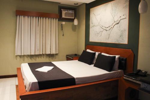 Un dormitorio con una cama y un escritorio con teléfono. en Hotel Extasy (Adult Only), en São Vicente