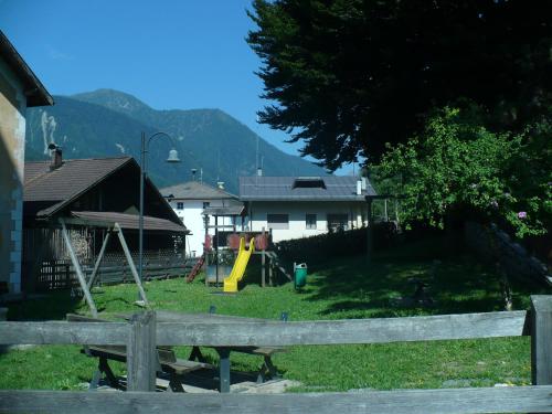 a yard with a playground and a house at Casa Danoli in Canale San Bovo