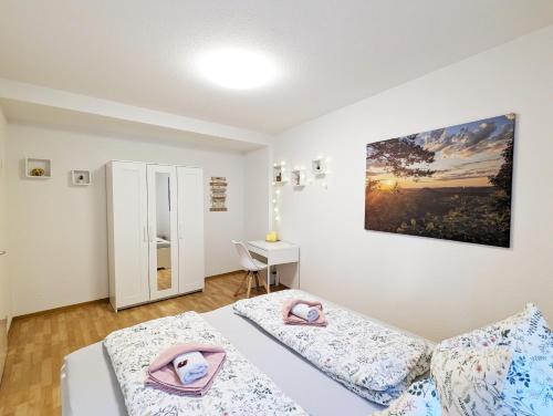 a bedroom with two beds and a desk at HW2B - Urlaubsmagie - Wohlfühlwohnung mit Balkon, Pool, Sauna & Terrasse in Sebnitz