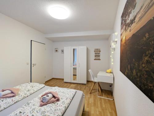 a small bedroom with two beds and a desk at HW2B - Urlaubsmagie - Wohlfühlwohnung mit Balkon, Pool, Sauna & Terrasse in Sebnitz