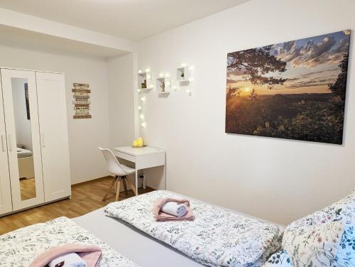 a small room with two beds and a desk at HW2B - Urlaubsmagie - Wohlfühlwohnung mit Balkon, Pool, Sauna & Terrasse in Sebnitz