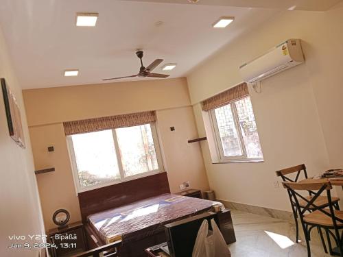 a room with a bed and a ceiling fan at The Broome Kolkata in Kolkata