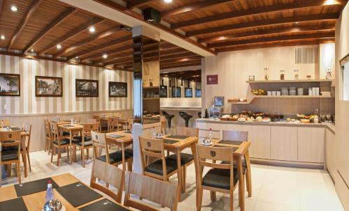 a restaurant with wooden tables and chairs and a counter at Bellagio Mini Resort - no coração de Gramado in Gramado