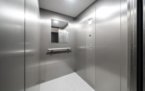 a bathroom with a silver elevator with a mirror at Aparthotel Zell am See (Contactless Check-In) in Zell am See