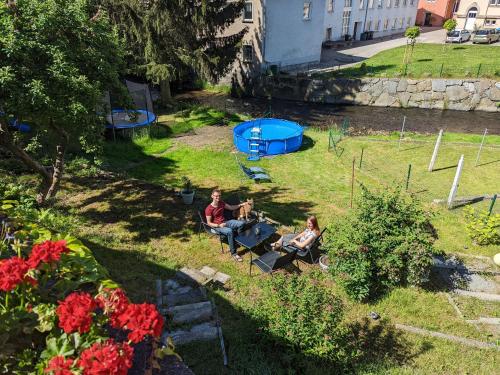 a group of people sitting in a yard at HW2B - Urlaubsmagie - Wohlfühlwohnung mit Balkon, Pool, Sauna & Terrasse in Sebnitz