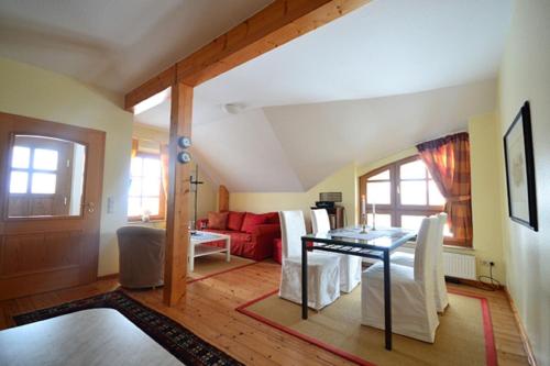 a living room with a table and a red couch at Appartement "Romantika" in Klink