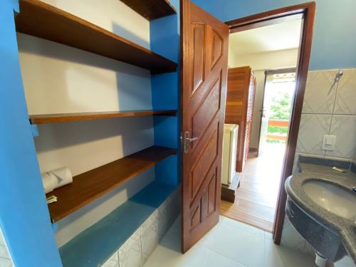 a bathroom with a sink and a toilet and a door at Pousada Peterle in Domingos Martins