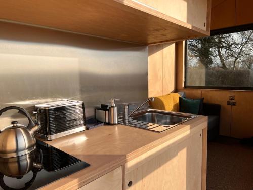 eine Küche mit Spüle und Toaster in der Unterkunft The Coppleridge Inn, Eco-friendly cabins in the Dorset countryside with heating and hot water in Shaftesbury