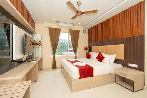 um quarto com uma cama e uma televisão de ecrã plano em Hotel Brindavan Elite em Rameswaram