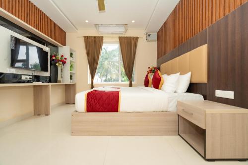 um quarto com uma cama grande e uma televisão em Hotel Brindavan Elite em Rameswaram