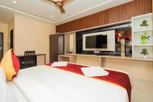 um quarto com uma cama grande e uma televisão em Hotel Brindavan Elite em Rameswaram