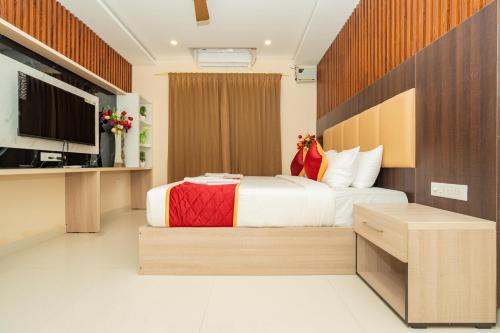 um quarto de hotel com uma cama e uma televisão em Hotel Brindavan Elite em Rameswaram