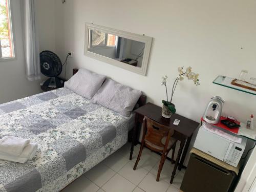 Dormitorio pequeño con cama y mesa en Adelaide Suite, en Fortaleza