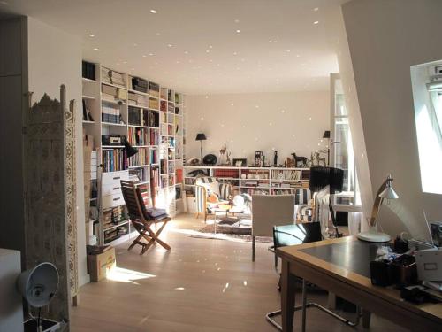 un salon avec un bureau et une chambre avec des livres dans l'établissement PARIS SOUS LES TOITS, à Paris