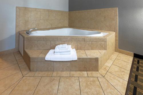 a bathroom with a tub with towels in it at La Quinta by Wyndham Mt. Pleasant in Mount Pleasant