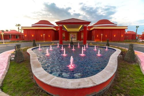 a fountain with pink fountains in front of a building at Pickalbatros Laguna Club Resort Sharm El Sheikh in Sharm El Sheikh
