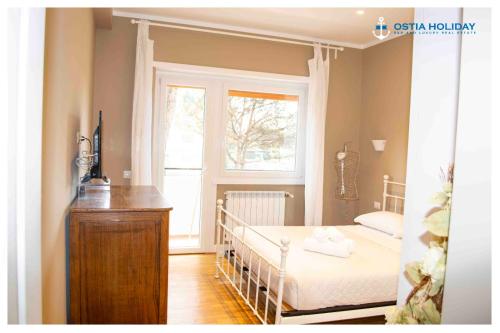a small bedroom with a crib and a window at Appartamento Executive Home in Lido di Ostia
