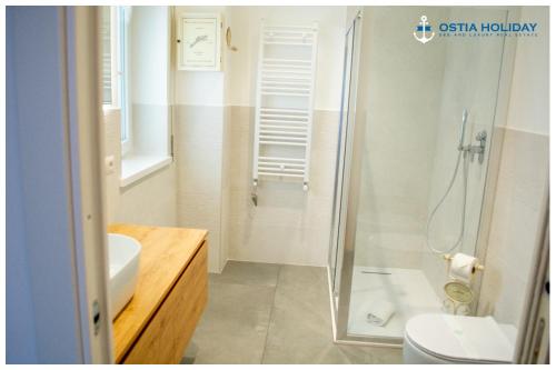 a bathroom with a shower and a toilet and a sink at Appartamento Executive Home in Lido di Ostia