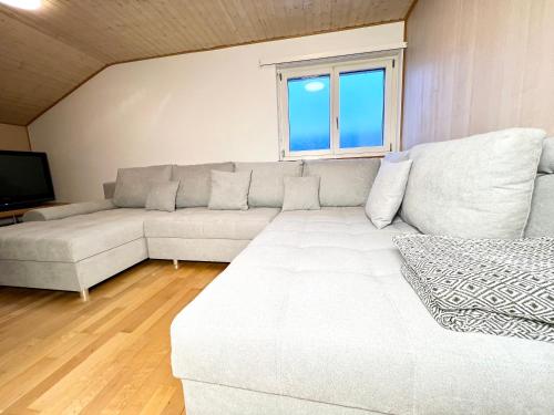 a living room with a white couch and a television at Glishorn Blick in Brig