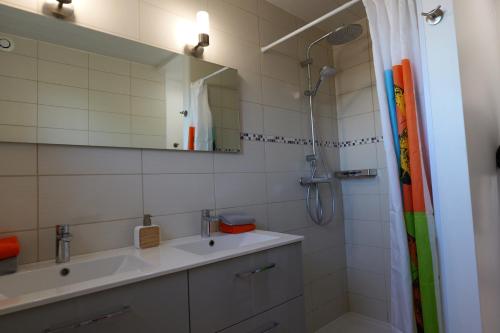 a bathroom with a sink and a shower with a mirror at VILLA BOIS LAUZON in Orange