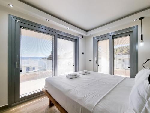 キオスにあるXENIA LUXURY APARTMENTS CHIOSのベッドルーム(大きなベッド1台、大きな窓付)