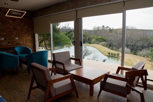 a room with chairs and a table and a large window at Cabaña La Reserva Suite in La Granja