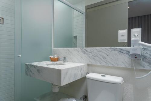 a bathroom with a marble sink and a toilet at Vistamar Hotel in Maceió