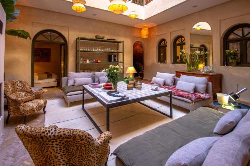 - un salon avec un canapé et une table dans l'établissement Maison Beryll, à Marrakech