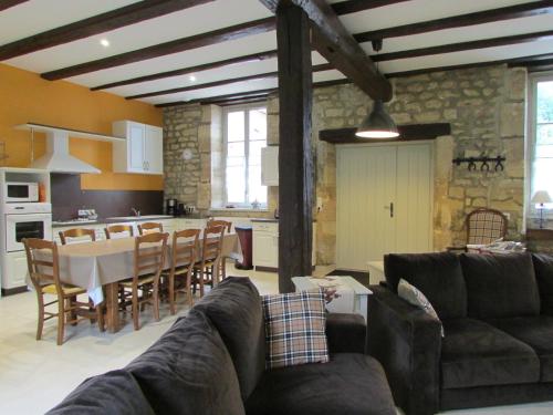 een woonkamer met een tafel en stoelen en een keuken bij Gites de Jeand'Heurs in Lisle-en-Rigault