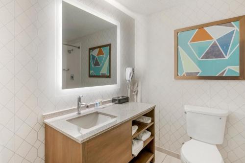 a bathroom with a sink and a toilet and a mirror at Comfort Inn & Suites Louisville Airport Fair & Expo in Louisville
