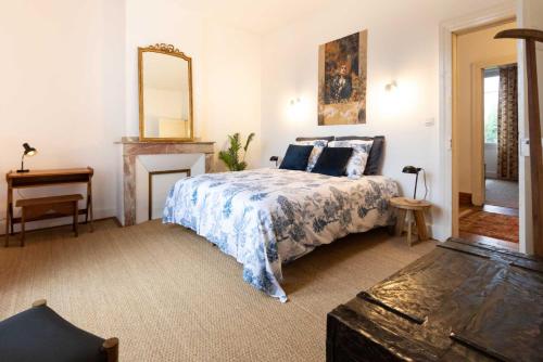 une chambre avec un lit et un miroir au mur dans l'établissement Villa Cécile - Climatisée avec jardin et parking, à Albi