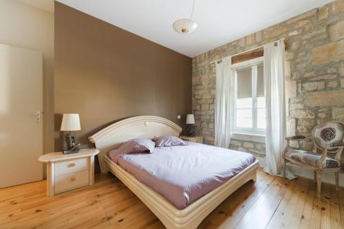 een slaapkamer met een bed en een bakstenen muur bij Gites de Jeand'Heurs in Lisle-en-Rigault