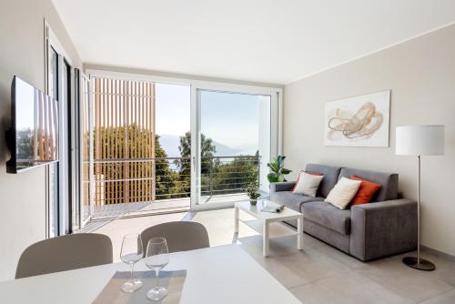 a living room with a couch and a large window at Residence Conca Verde 2 with pool in Trarego Viggiona