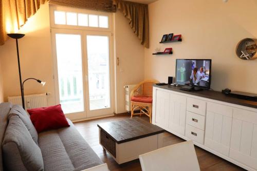 ein Wohnzimmer mit einem Sofa und einem TV in der Unterkunft Strandstraße 14 - 51-1 in Kühlungsborn