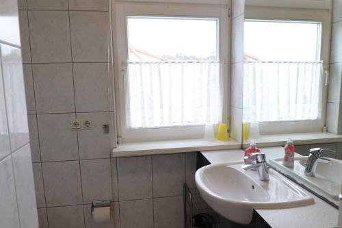 ein Bad mit einem Waschbecken und einem Spiegel in der Unterkunft Strandstraße 14 - 51-1 in Kühlungsborn