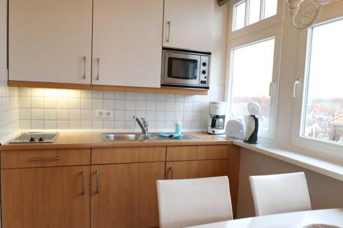 eine Küche mit einer Spüle und einer Mikrowelle in der Unterkunft Strandstraße 14 - 51-1 in Kühlungsborn