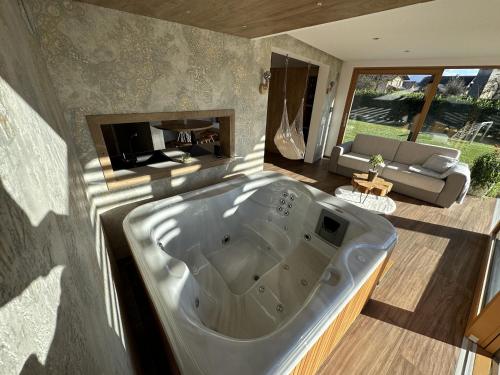 uma grande banheira numa sala de estar com um sofá em Luxury Resort Potatoland em Šenčur