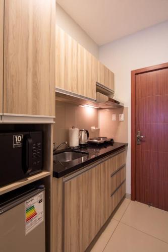 a kitchen with a sink and a microwave at Equipetrol Suites apart hotel in Santa Cruz de la Sierra
