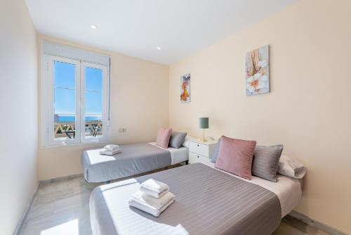 1 dormitorio con 2 camas y ventana en Chalet in Torrequebrada residencial golf urbanization, en Torrequebrada