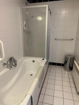 a white bathroom with a shower and a tub at Ostrea 4 in Nes