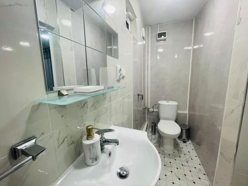 Un baño blanco con lavabo e inodoro. en Studio 21, en Varna