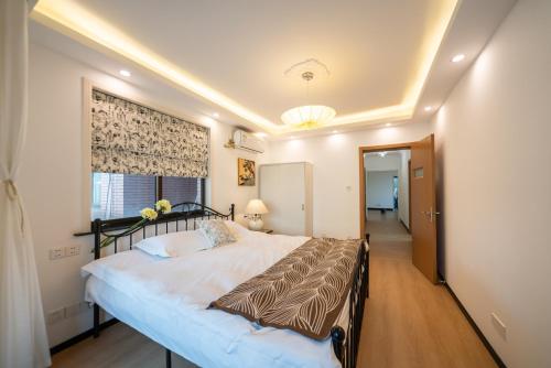 a bedroom with a large bed in a room at Shanghai Yi Du B&B - Family Suite 500m to Nanjing West Rd Near People's Square -Credit Cards Accepted in Shanghai
