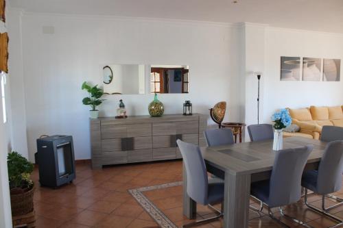 sala de estar con mesa de madera y sillas en Casa La Romana, en Aracena