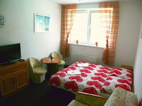 Un dormitorio con una cama roja y blanca y una ventana en Apartman Dinda, en Tatranská Lomnica