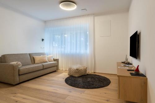 a living room with a couch and a tv at Mountain Meadows Apt 4 in Valdaora